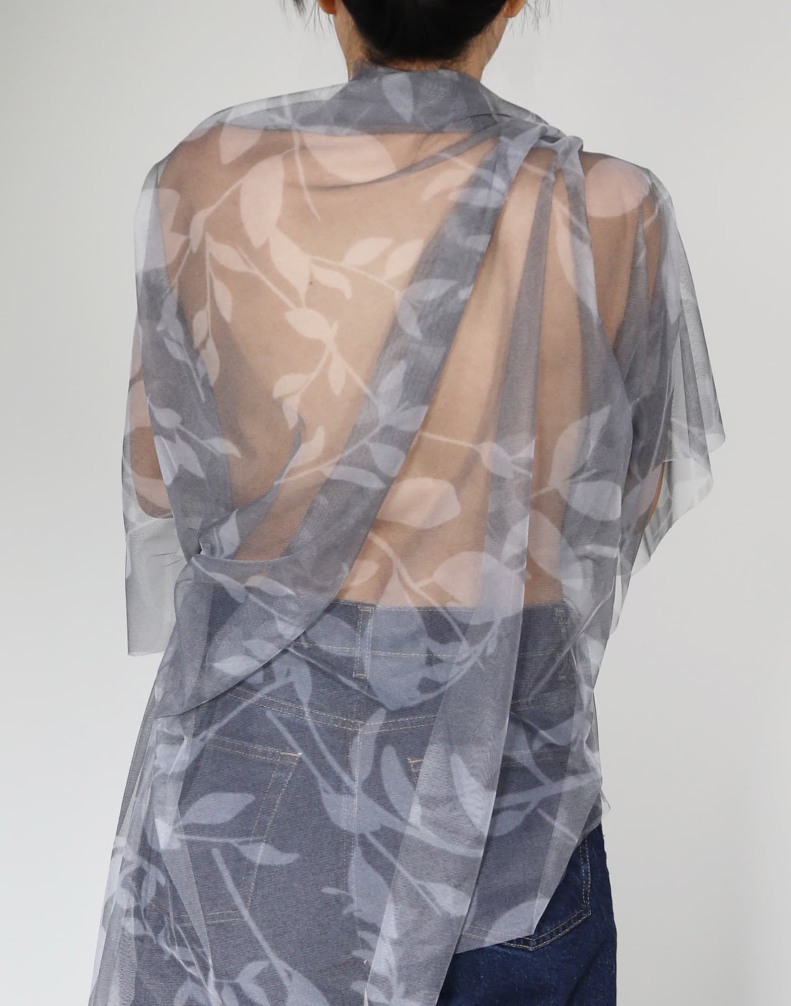 Model wearing a sheer grey leaf-print wrap from the Quiet Gray sub-collection