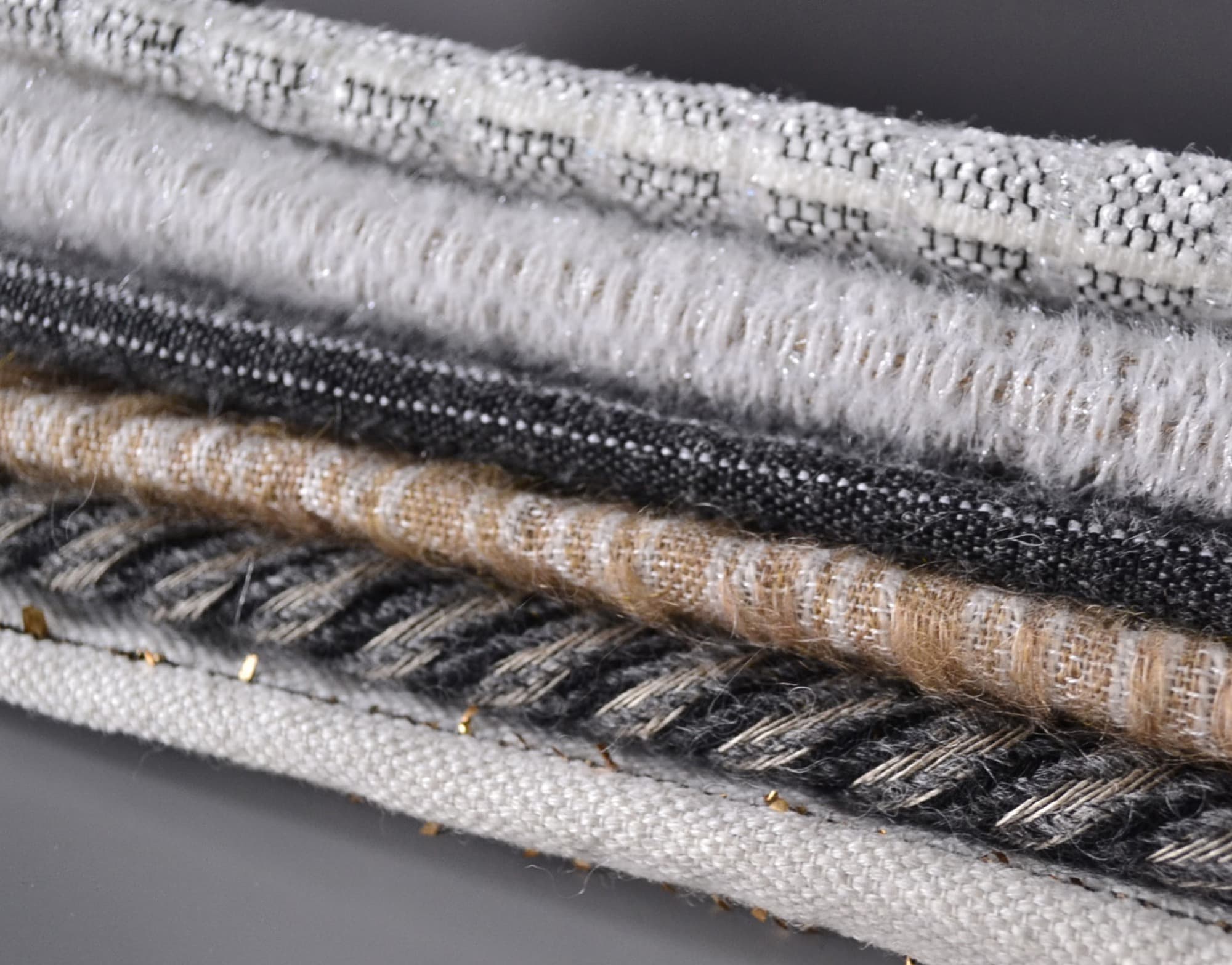 Stack of handwoven textile samples in black, white, and neutral yarns