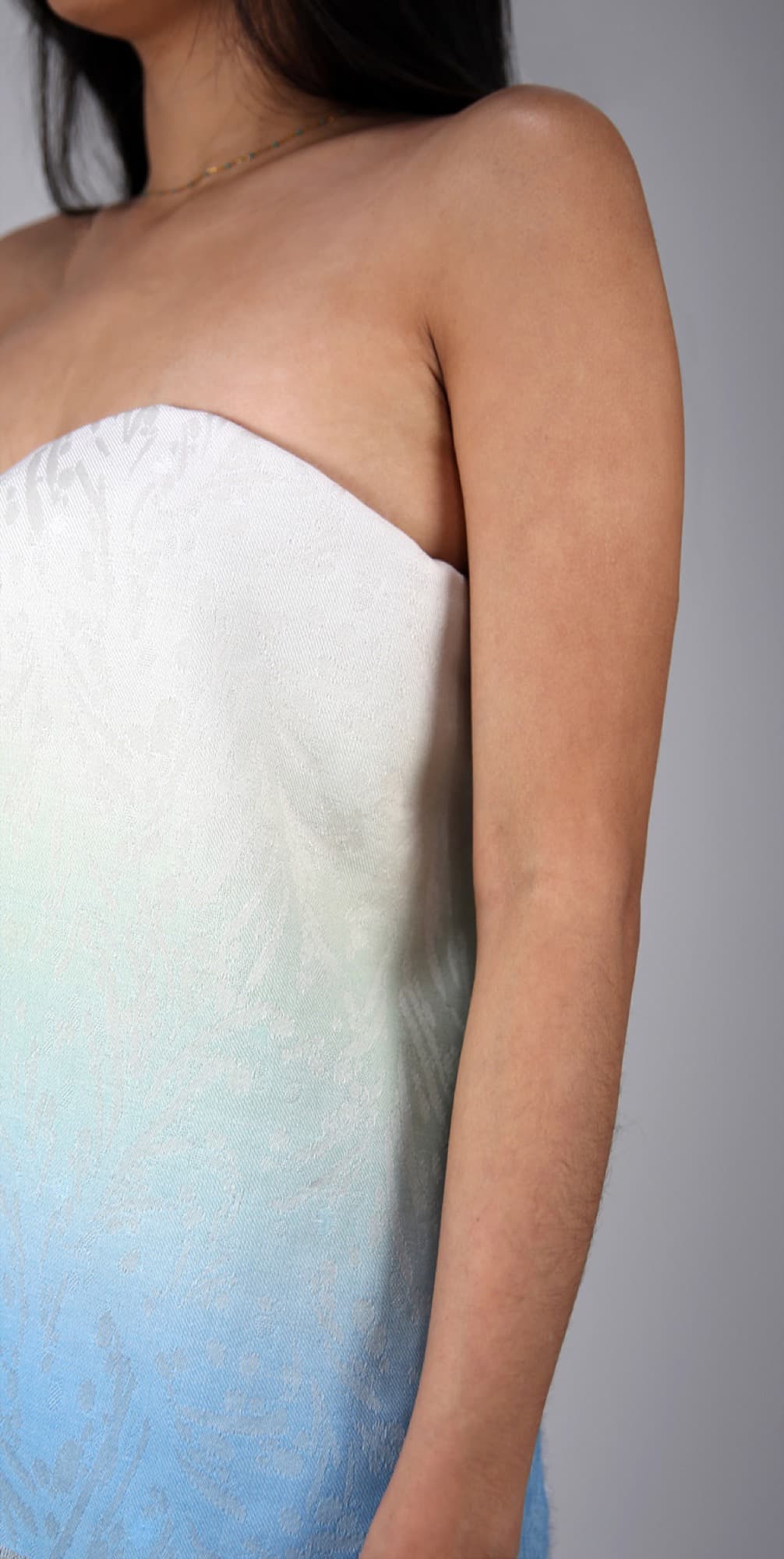 Close-up of blue ombre woven textile against skin
