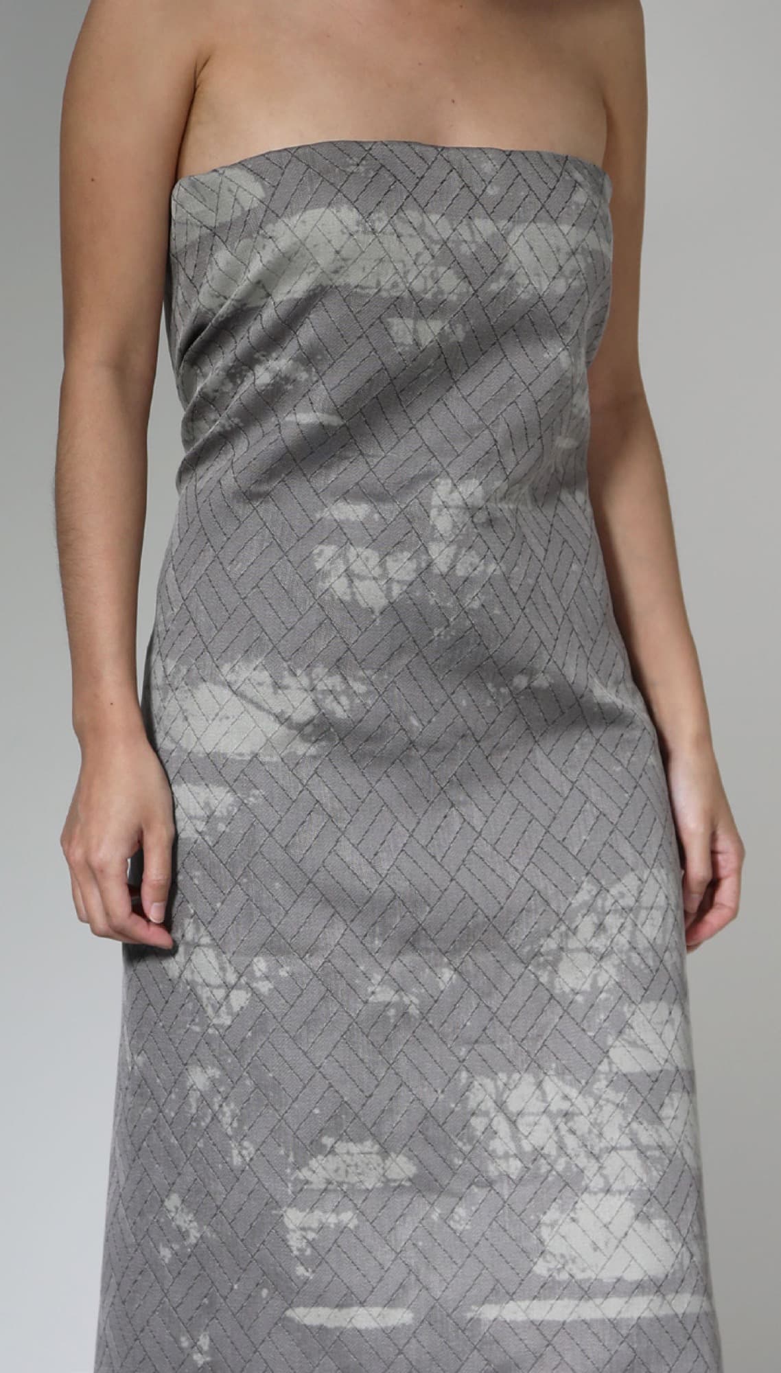 Grey diamond-weave textile draped as a gown